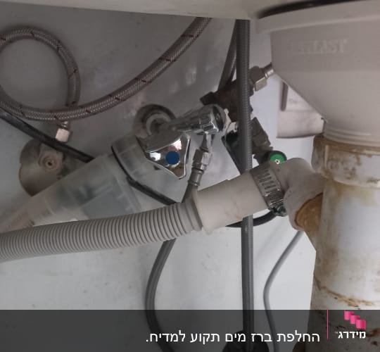 צינורות מתכת ופלסטיק מתחת לכיור עם מחברים